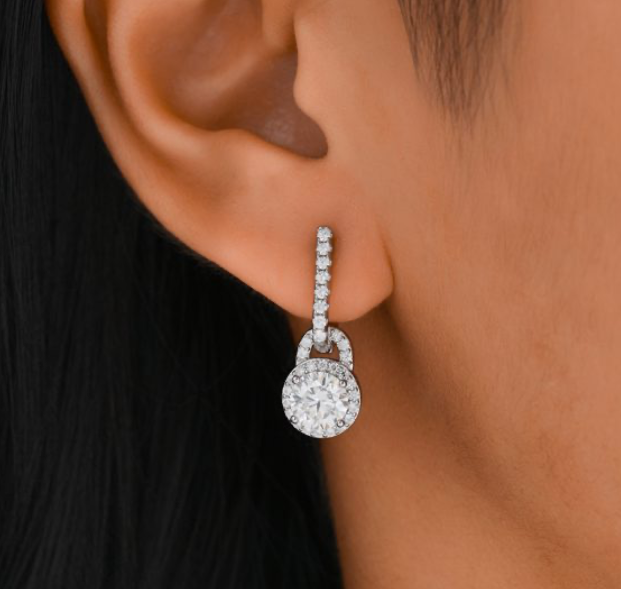 Brincos pendentes em prata 925 com moissanite central e halo de pedras, suspensos de barra em pavé. Elegantes.