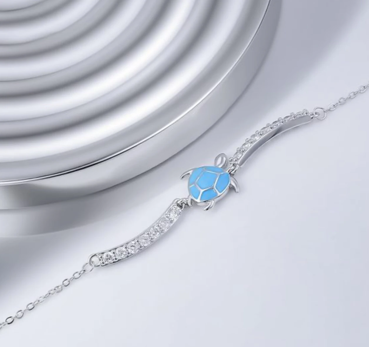 Blue sea turtle cubic zirconia 925 sterling silver bracelet on a silver surface