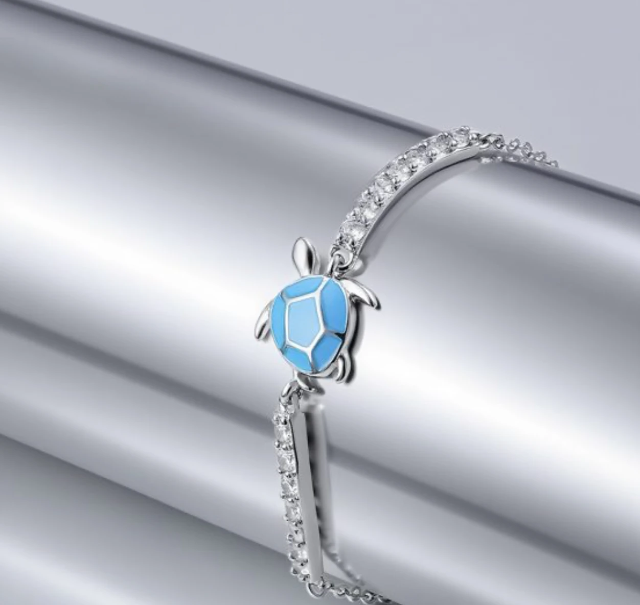 Blue sea turtle cubic zirconia 925 sterling silver bracelet on a silver surface