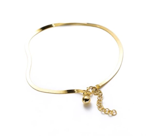 Gold-tone flat snake chain anklet with round bead dangle on a white background