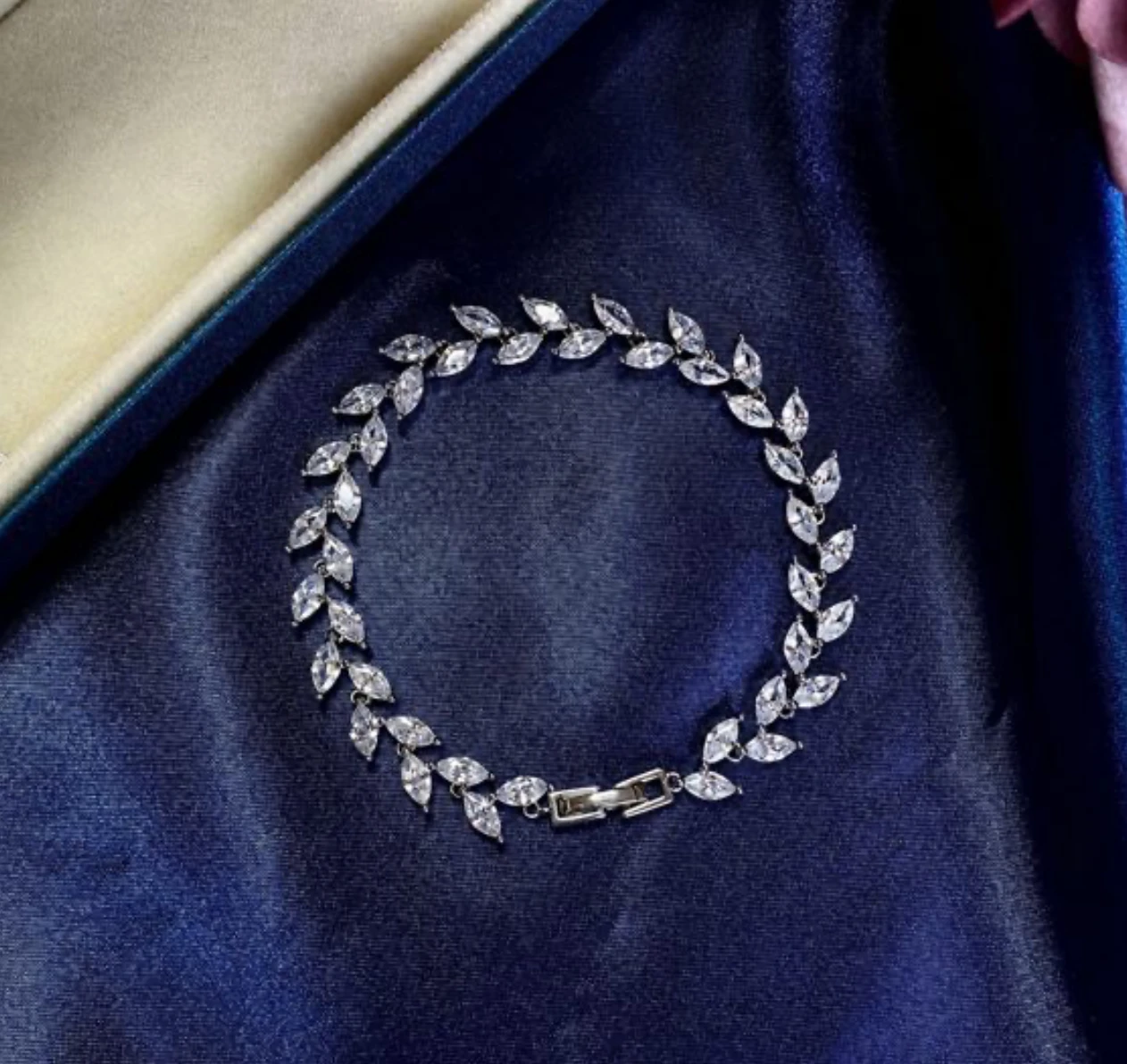 Silver marquise-cut zirconia vine link bracelet on satin background