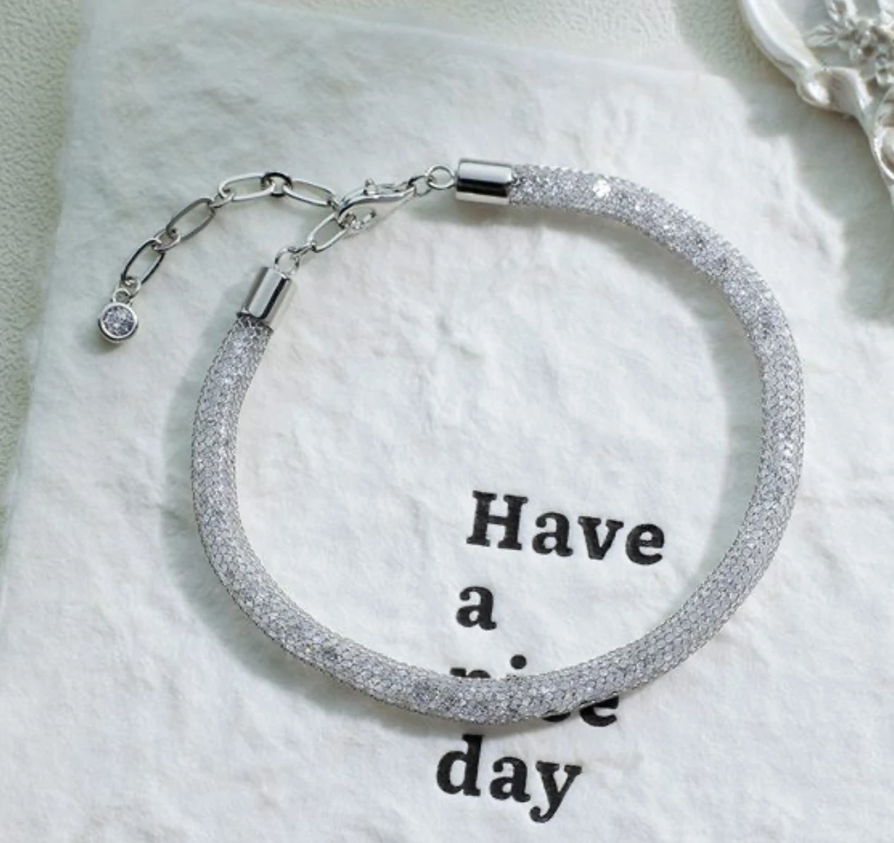 Elegant geometric shimmering mesh 925 silver bracelet in silver on textured paper